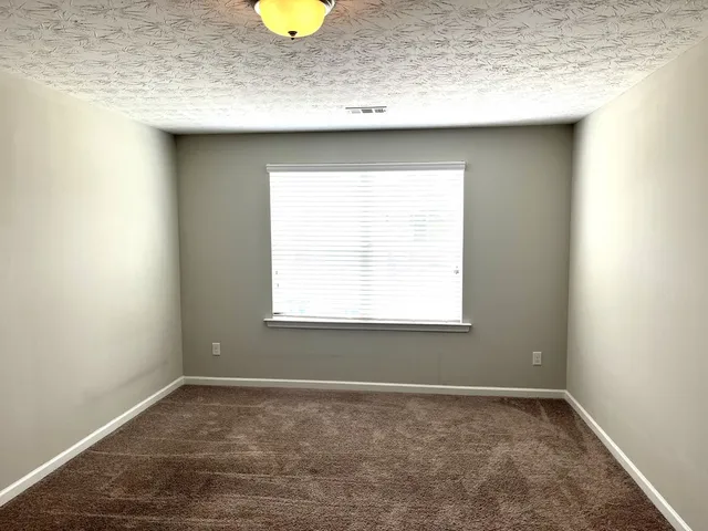 a view of a sink a window and cabinets