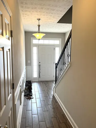 a view of a hallway with wooden floor and staircase