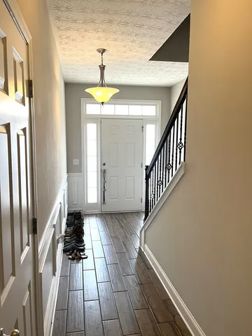 a view of a hallway with wooden floor and staircase