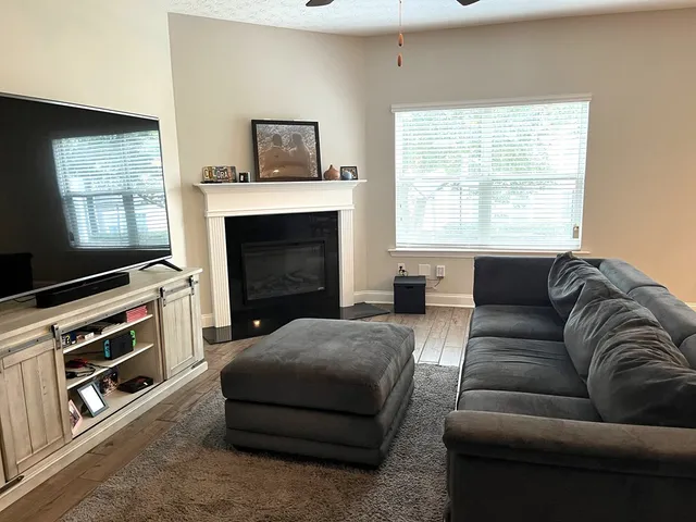 a living room with furniture a flat screen tv and a fireplace
