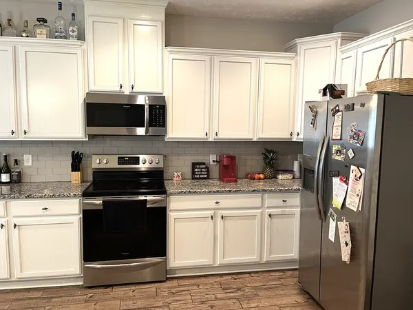 a kitchen with stainless steel appliances granite countertop a refrigerator sink and microwave