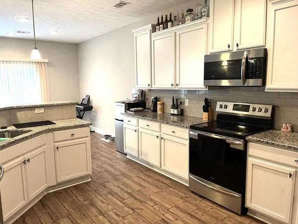 a kitchen with stainless steel appliances a stove sink microwave and cabinets