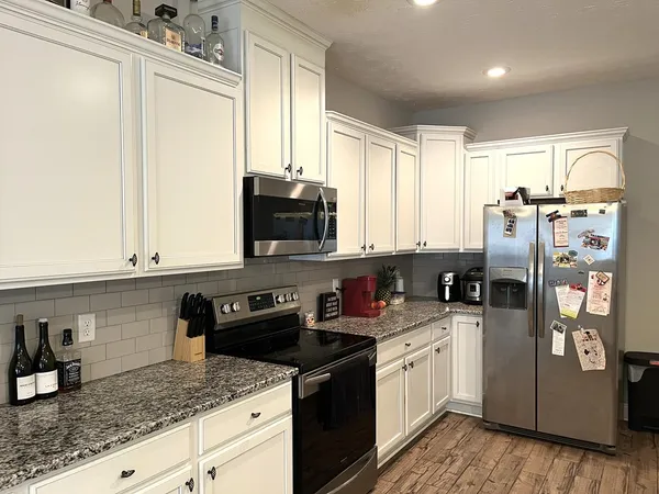 a kitchen with stainless steel appliances granite countertop a stove a sink and a refrigerator