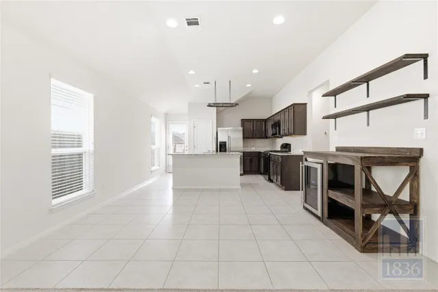 a large kitchen with stainless steel appliances granite countertop a stove and a refrigerator