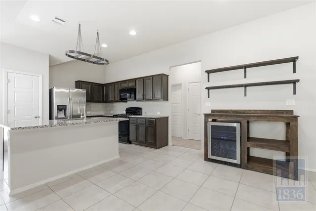 a kitchen with stainless steel appliances kitchen island granite countertop a sink and cabinets