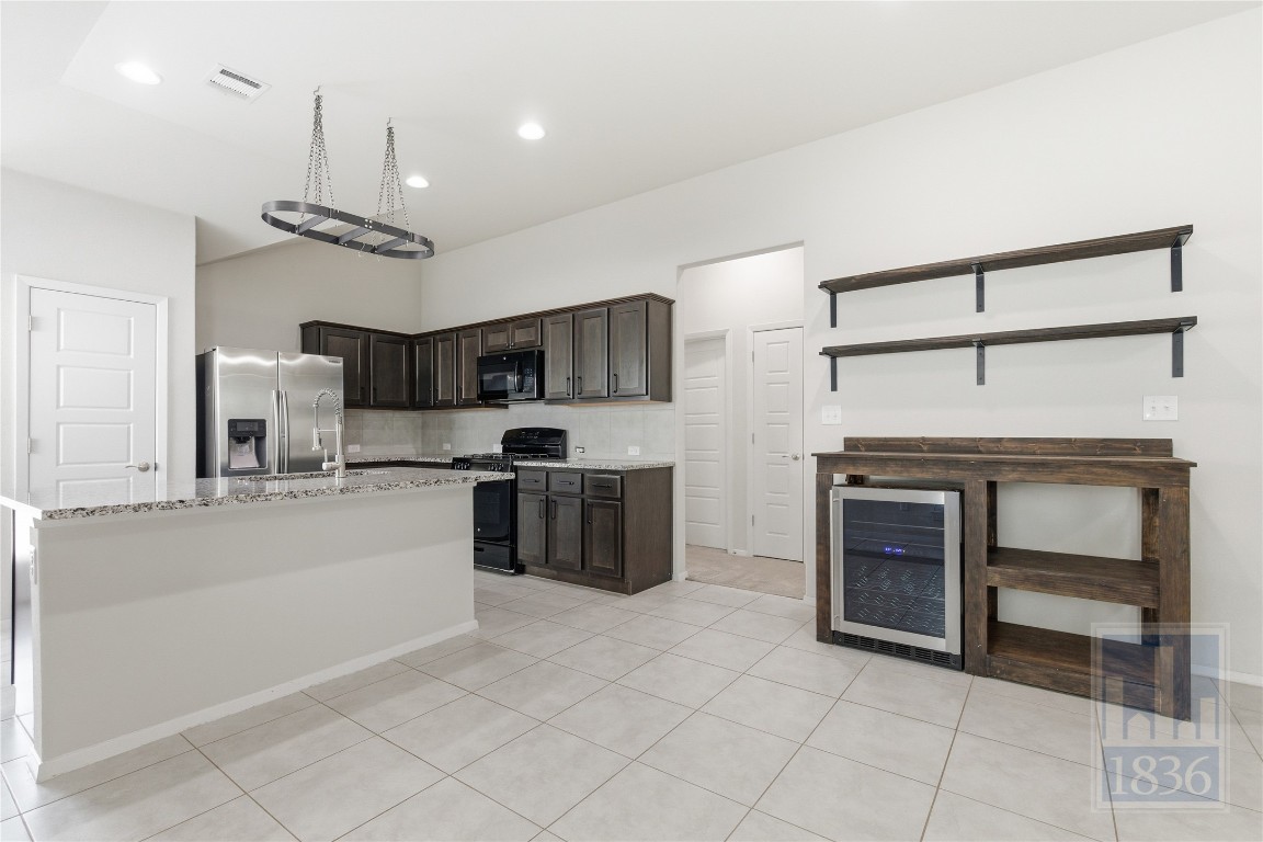 7615 Europa Avenue, Unit 139 Round Rock, TX 78665 - Photo 15 of 40 a kitchen with stainless steel appliances kitchen island granite countertop a sink and cabinets