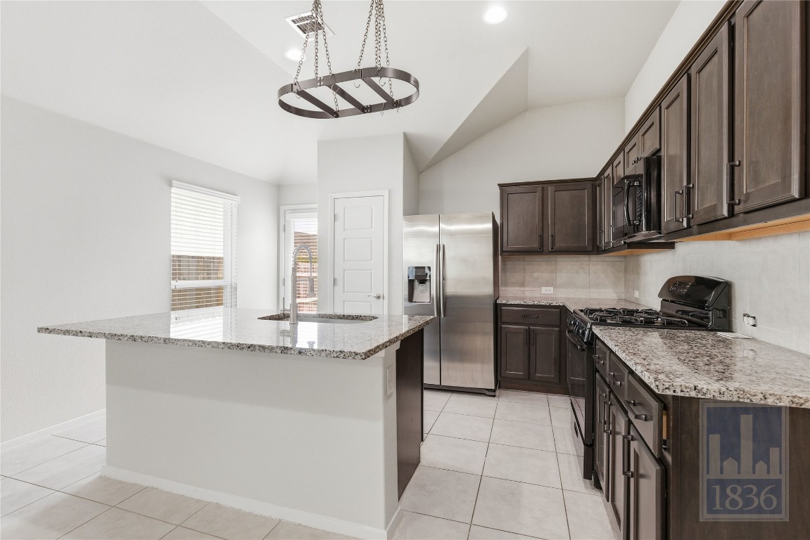 7615 Europa Avenue, Unit 139 Round Rock, TX 78665 - Photo 16 of 40 a kitchen with stainless steel appliances granite countertop a sink a stove a refrigerator cabinets and chairs