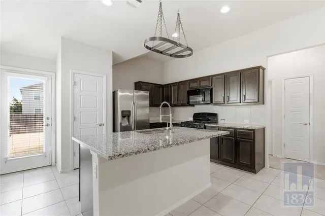 a kitchen with stainless steel appliances granite countertop a sink and stove top oven