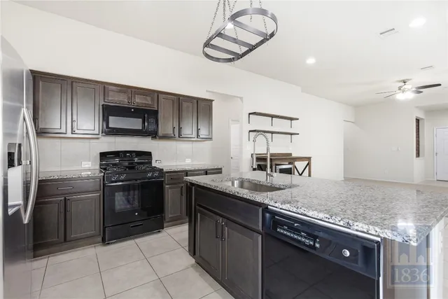 a kitchen with stainless steel appliances granite countertop a sink and stove top oven
