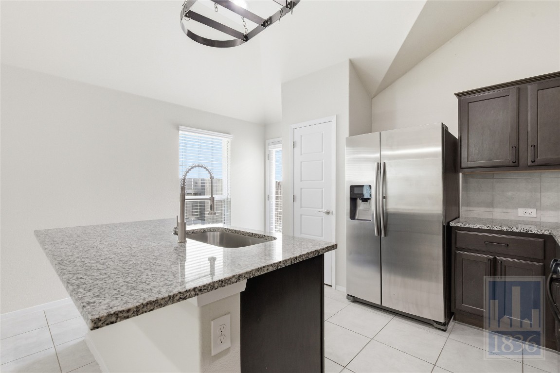 7615 Europa Avenue, Unit 139 Round Rock, TX 78665 - Photo 20 of 40 a kitchen with granite countertop a sink and a refrigerator
