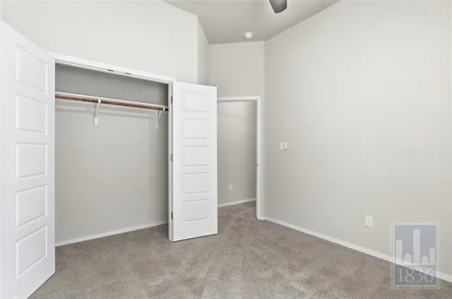an empty room with closet and mirror