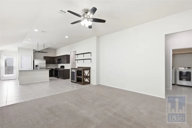a view of a livingroom with furniture and kitchen