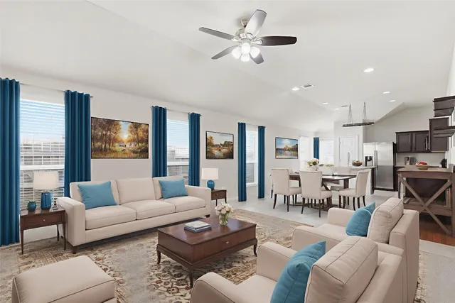 a living room with furniture kitchen view and a large window