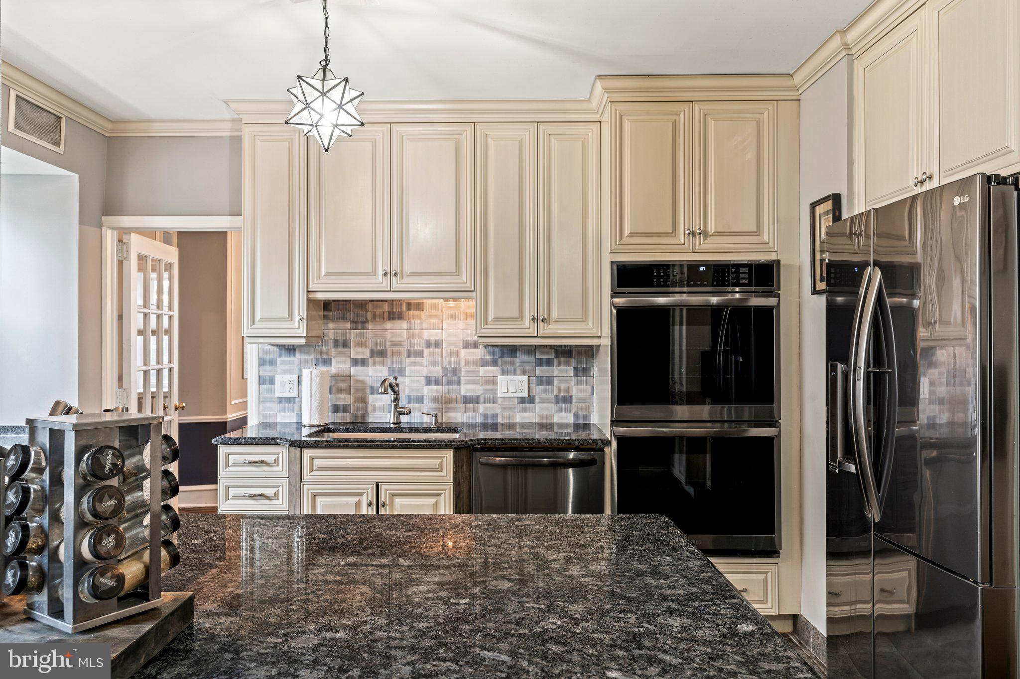2515 Garrett Road Drexel Hill, PA 19026 - Photo 24 of 61 a kitchen with stainless steel appliances kitchen island granite countertop a refrigerator a stove and a sink with wooden floor