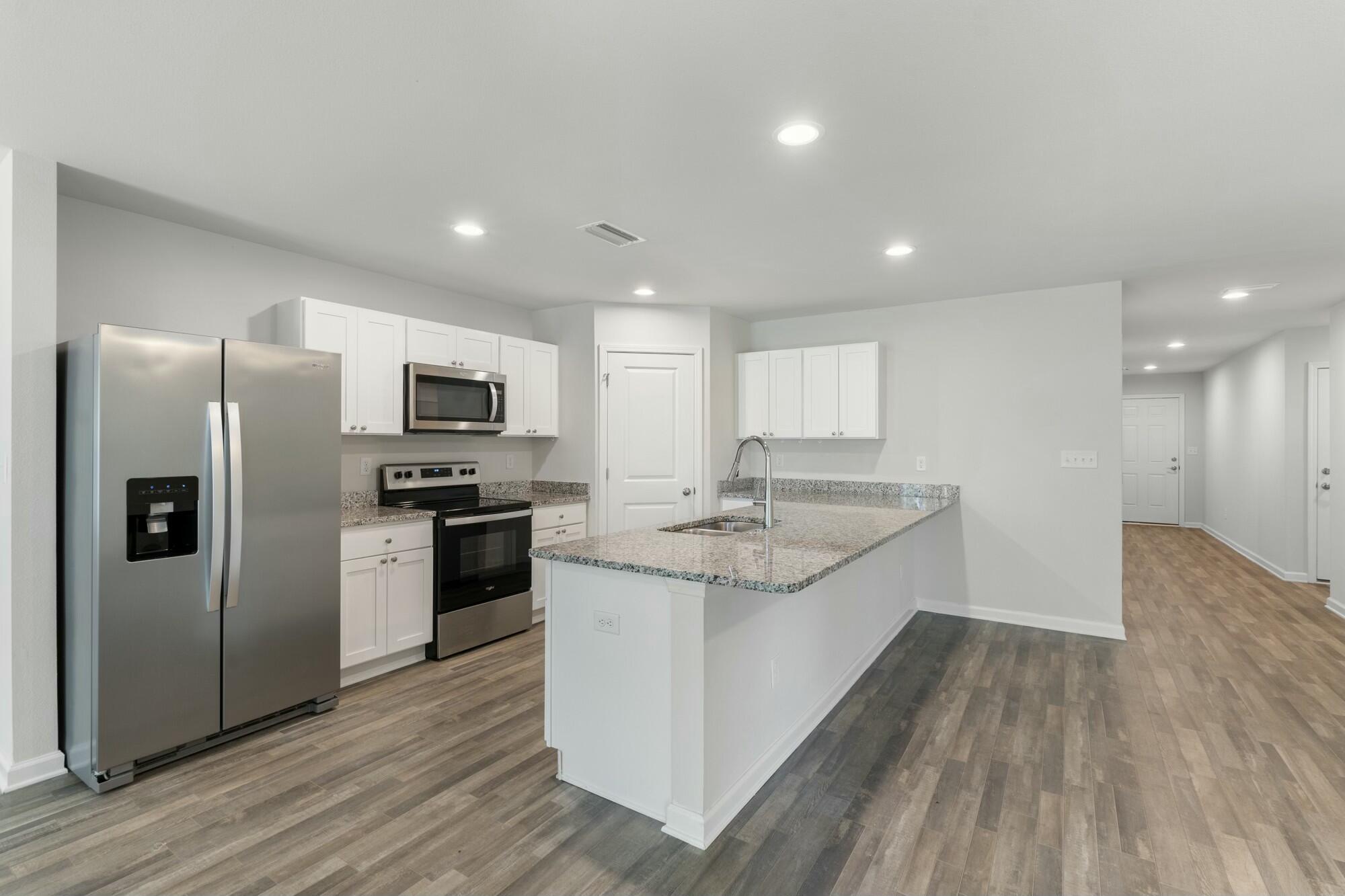 610 Riverwalk Circle Freeport, FL 32439 - Photo 13 of 50 a large kitchen with a center island wooden floor stainless steel appliances and cabinets