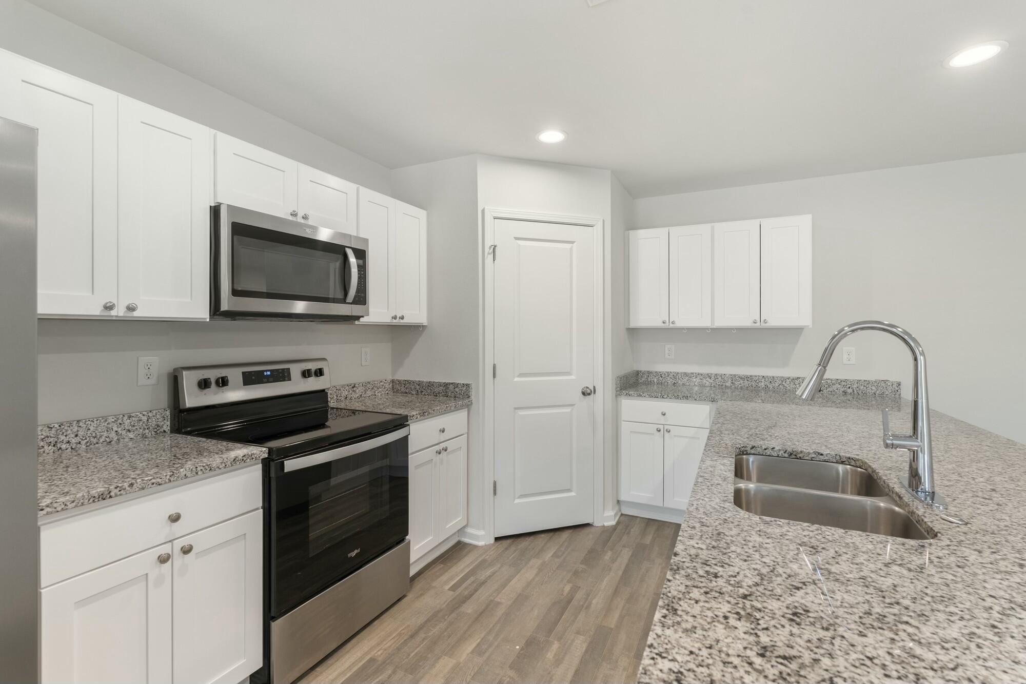 610 Riverwalk Circle Freeport, FL 32439 - Photo 15 of 50 a kitchen with granite countertop a stove a sink and a microwave