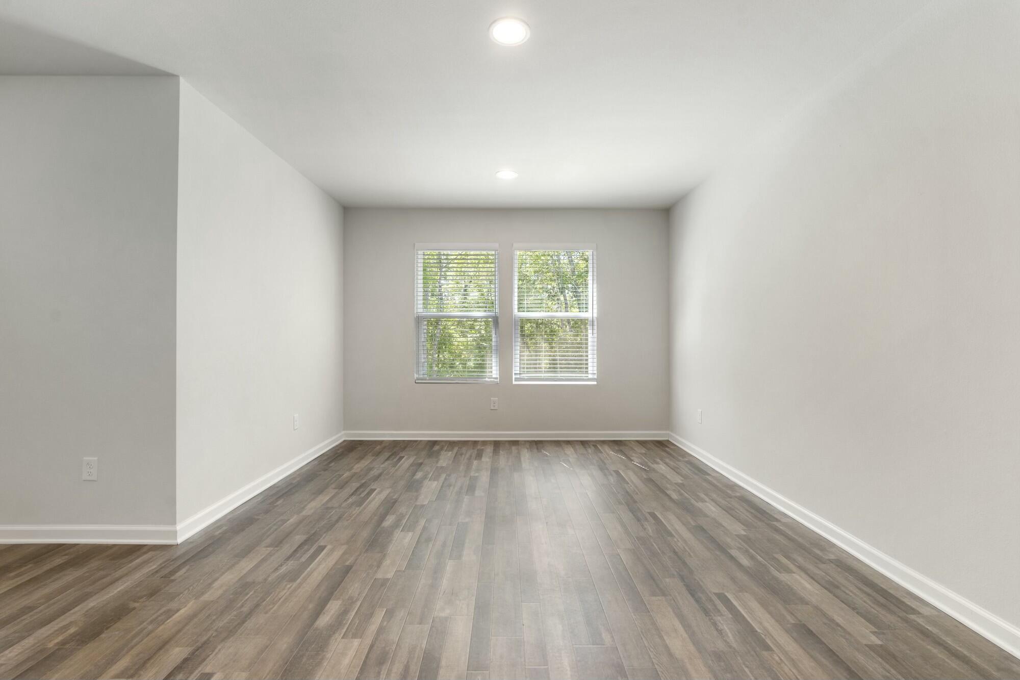 610 Riverwalk Circle Freeport, FL 32439 - Photo 19 of 50 an empty room with wooden floor and windows