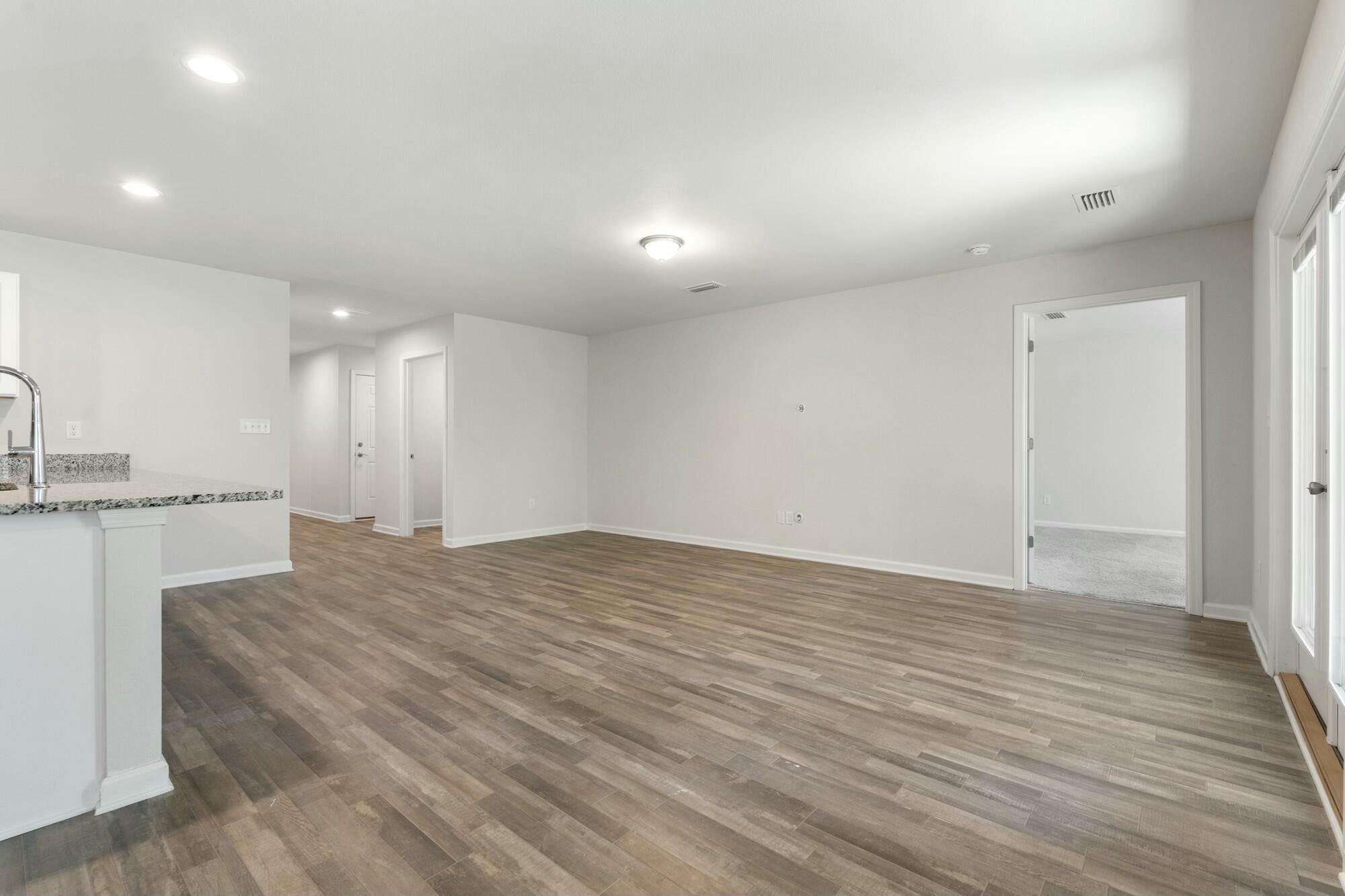 610 Riverwalk Circle Freeport, FL 32439 - Photo 20 of 50 a view of an empty room with wooden floor and a bathroom