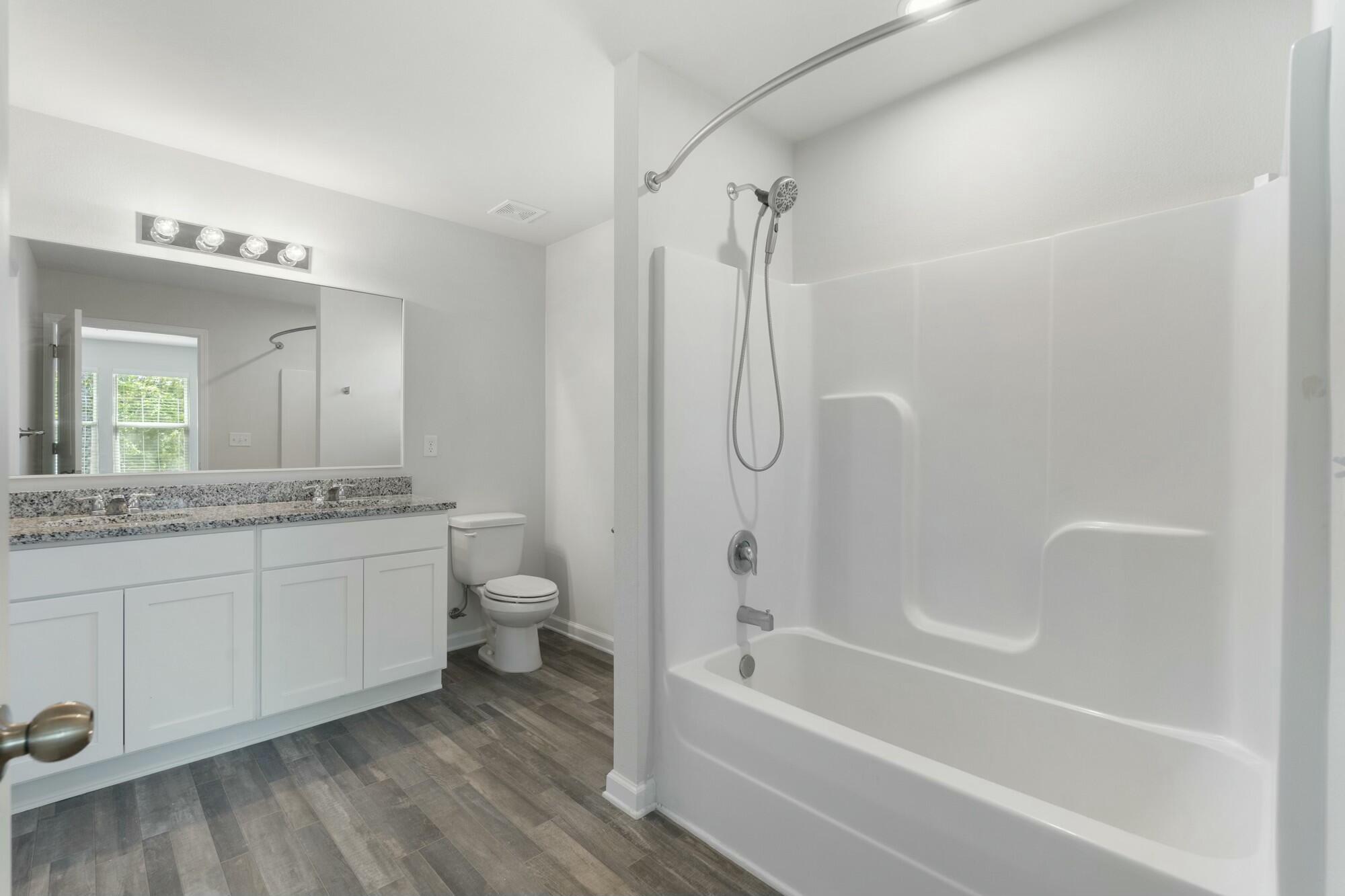 610 Riverwalk Circle Freeport, FL 32439 - Photo 24 of 50 a bathroom with a granite countertop toilet a sink and a bathtub