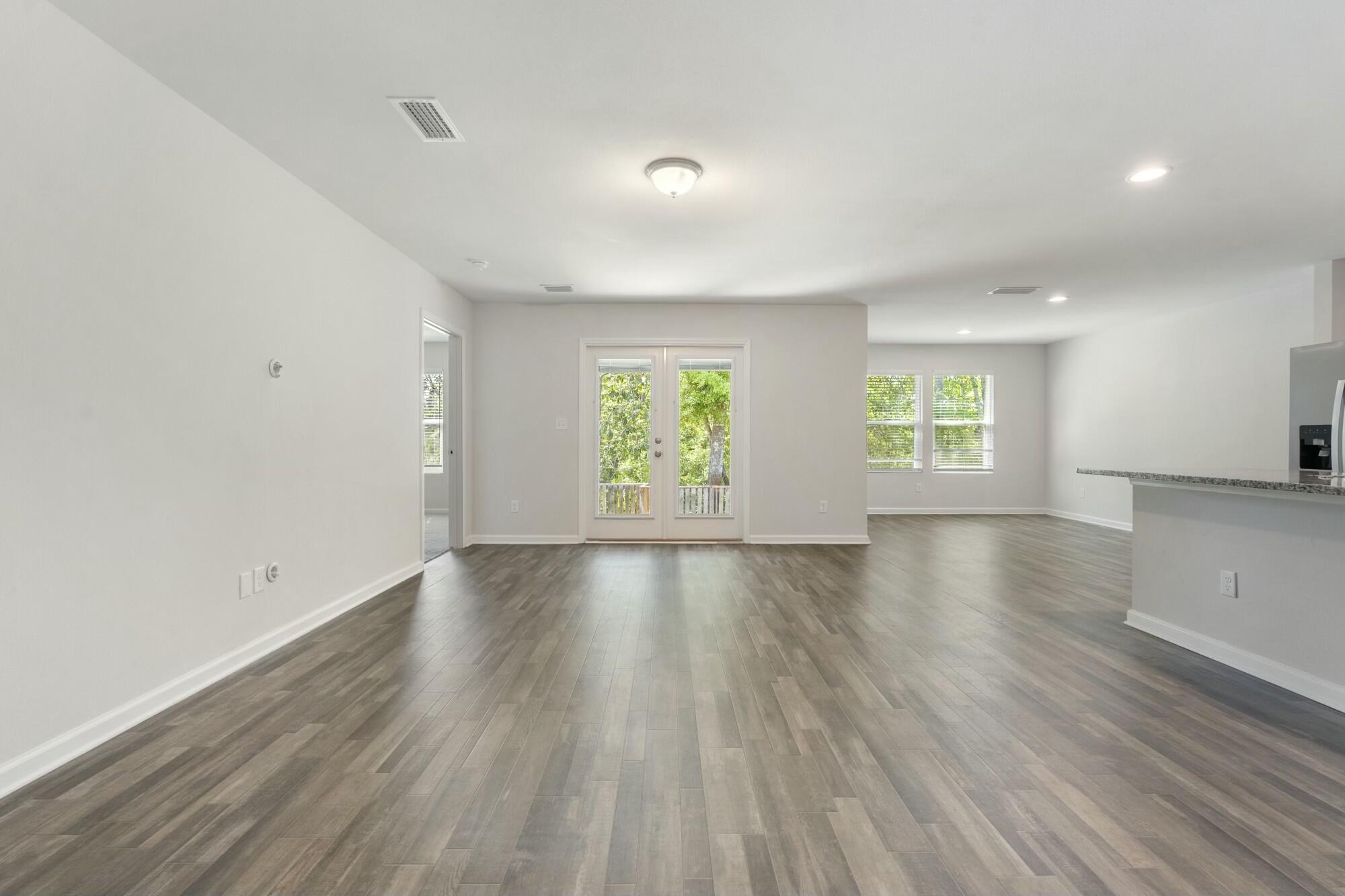 610 Riverwalk Circle Freeport, FL 32439 - Photo 8 of 50 an empty room with wooden floor and windows