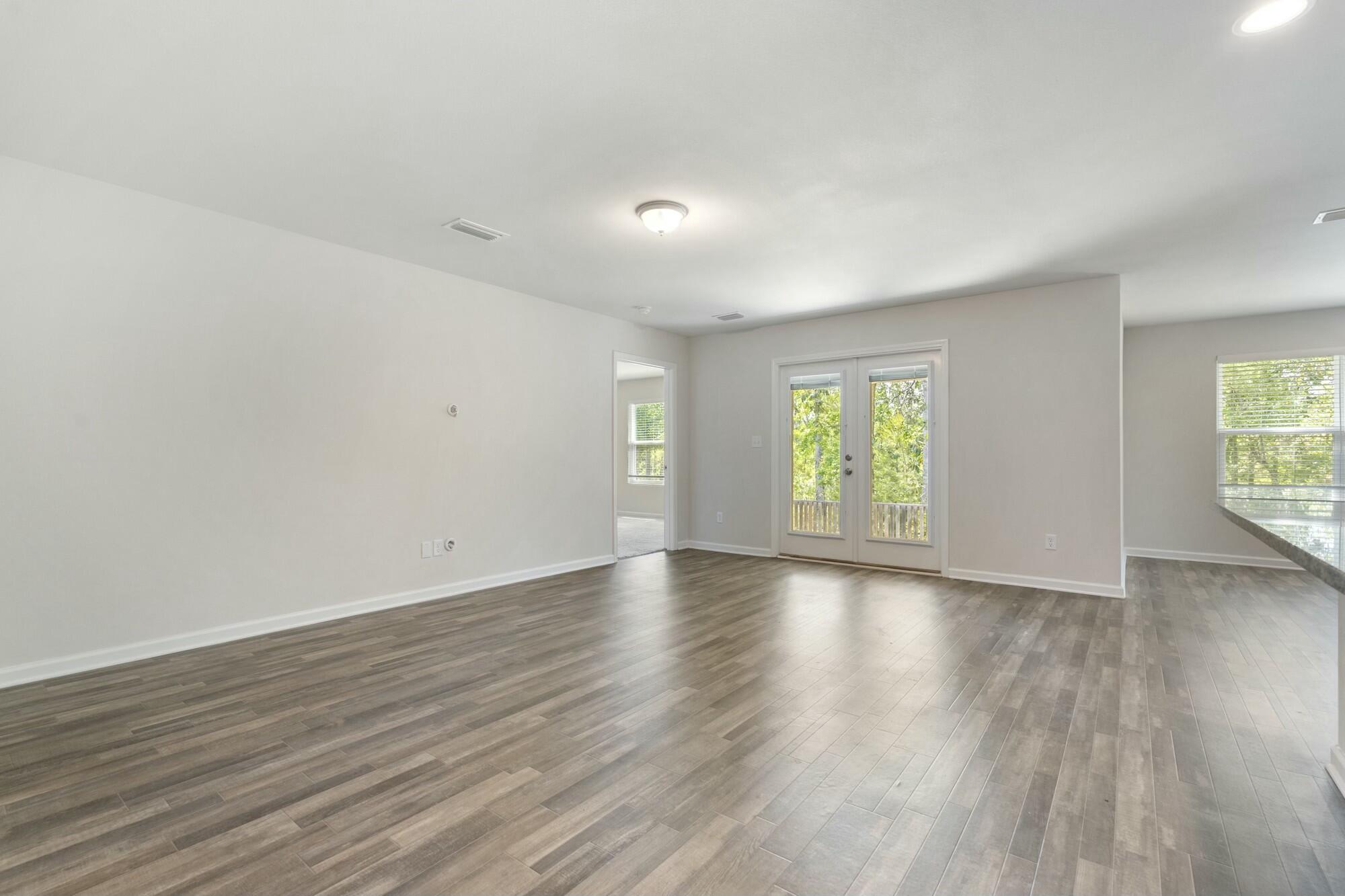610 Riverwalk Circle Freeport, FL 32439 - Photo 9 of 50 an empty room with wooden floor and windows