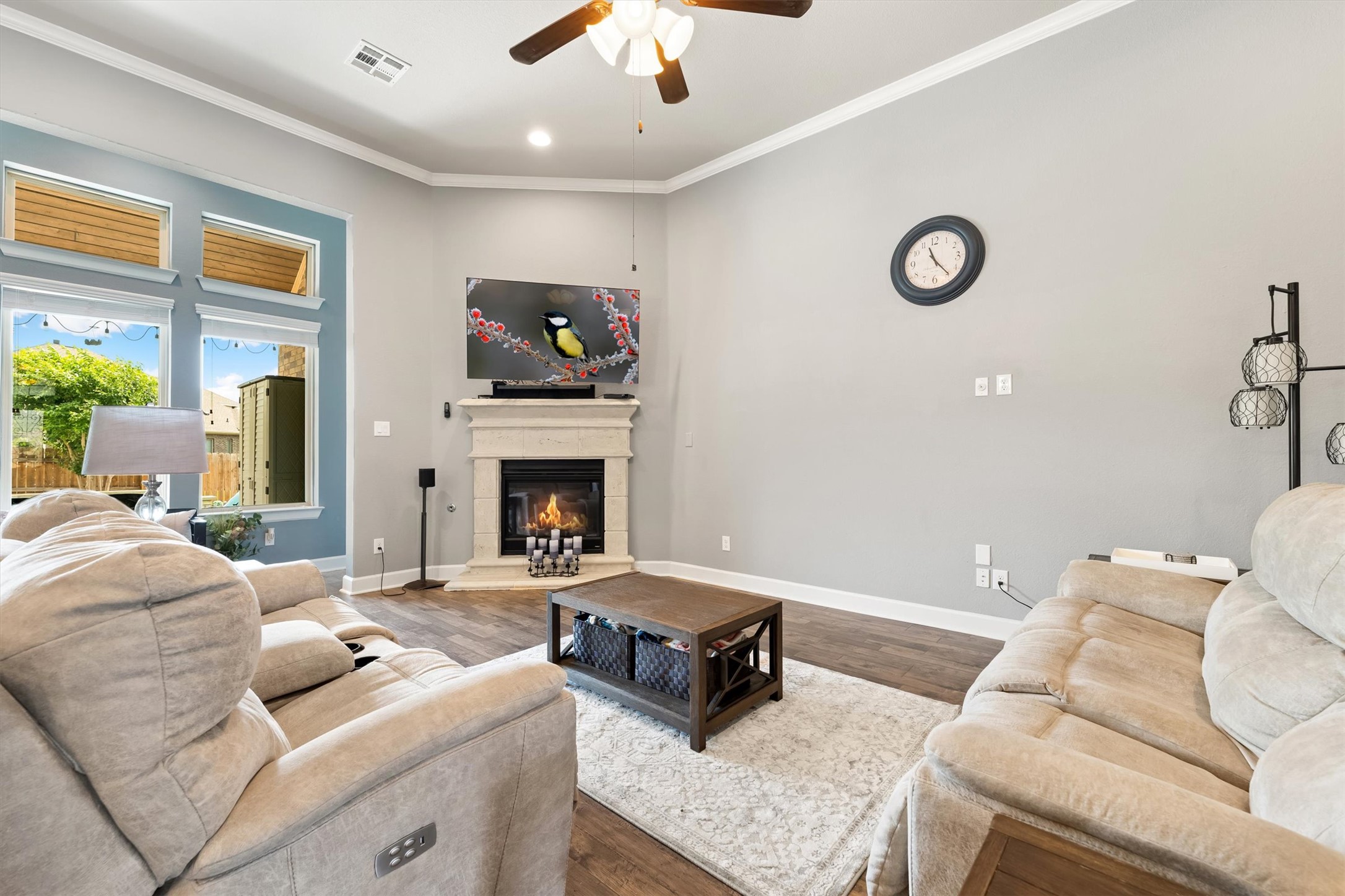 1004 Hezekiah Lane Leander, TX 78641 - Photo 6 of 36 Living area featuring a corner fireplace with a mantel, wood-finish flooring, and a ceiling fan