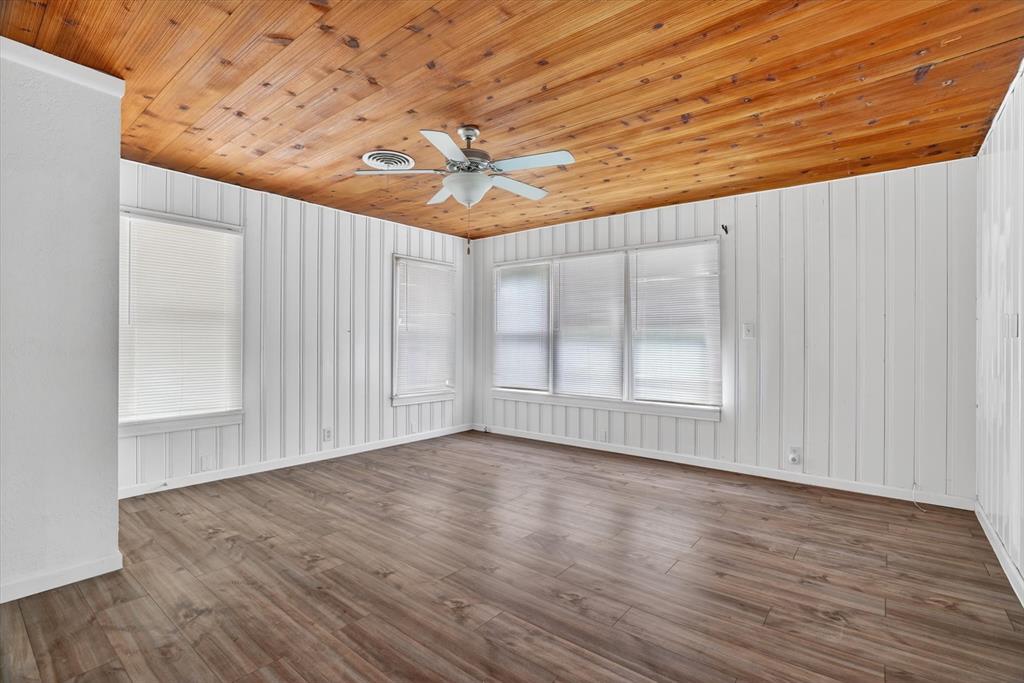 320 North 2nd Street Jacksboro, TX 76458 - Photo 8 of 16 en empty room with wooden floor and windows