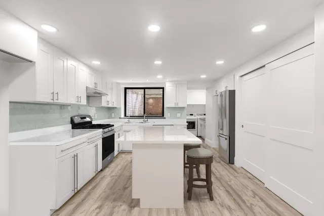 a bathroom with a shower sink vanity mirror and toilet