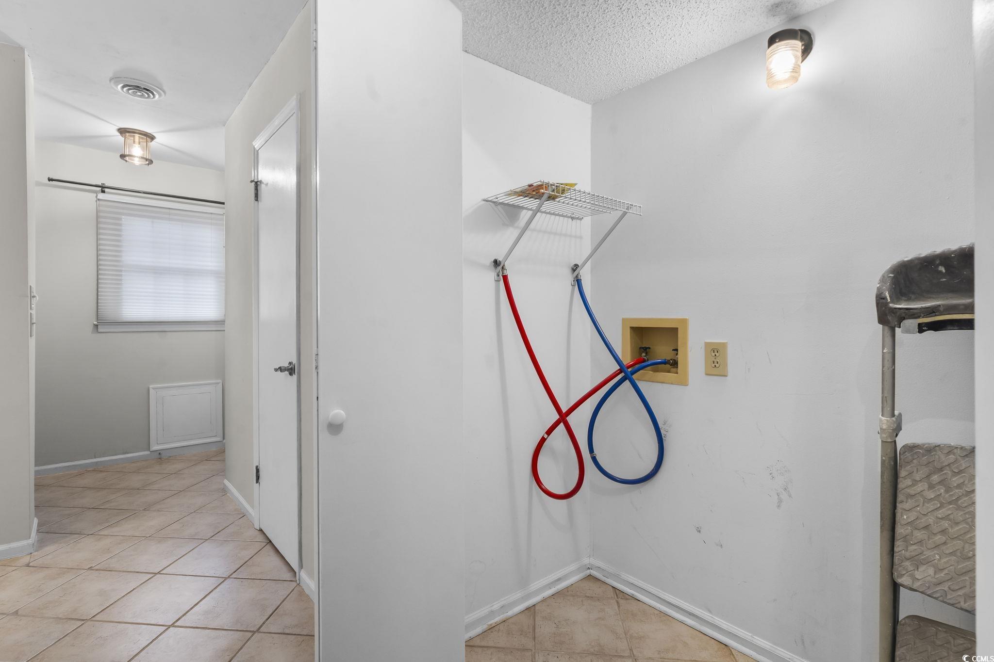 210 25th Avenue South, Unit 13 Myrtle Beach, SC 29577 - Photo 5 of 10 Laundry room with light tile patterned floors, hookup for a washing machine, and a textured ceiling