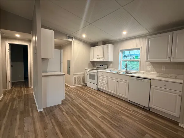 a kitchen with white cabinets and white appliances
