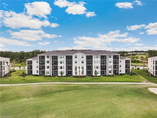 a large building with a big yard and trees