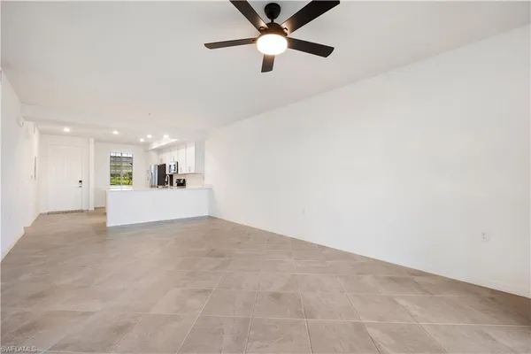a view of a livingroom with a ceiling fan and kitchen floor