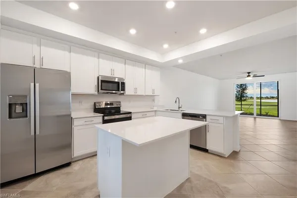 a kitchen with a sink a counter top space stainless steel appliances and cabinets