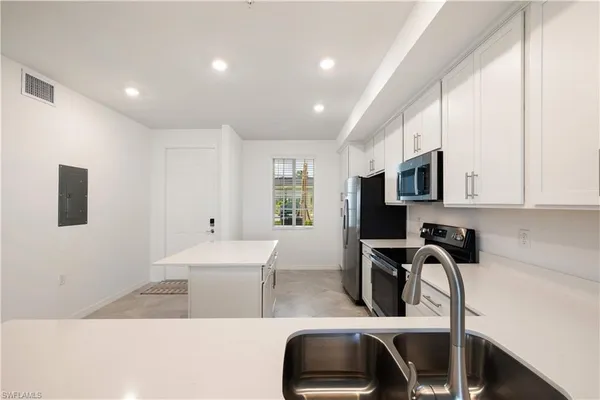 a kitchen with stainless steel appliances kitchen island granite countertop a sink and cabinets