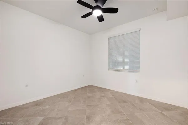 an empty room with a window and a fan