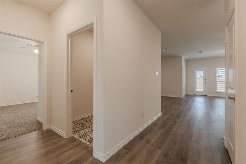 2902 Trusting Way Aubrey, TX 76227 - Photo 4 of 38 Hallway featuring wood-finish flooring, white baseboards, and neutral wall paint