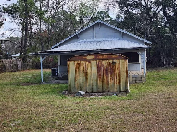 a view of a small house with a yard