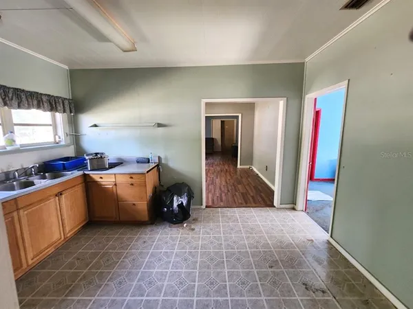 a large white kitchen with a sink a stove and a refrigerator