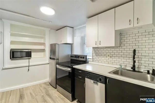 a kitchen with a sink appliances and cabinets