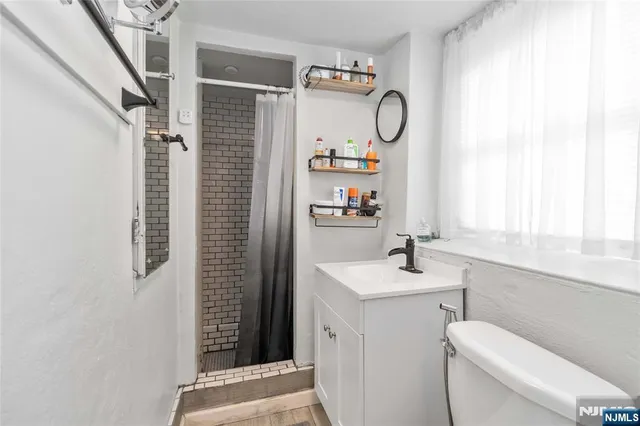 a bathroom with a sink toilet and a window