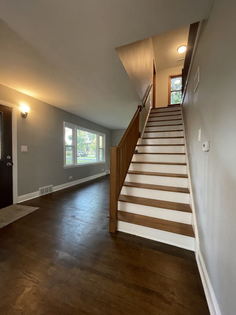 3-s284 Pattermann Road Warrenville, IL 60555 - Photo 12 of 21 a view of a livingroom with wooden floor and stairs