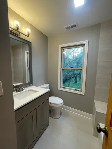 a bathroom with a toilet sink and mirror
