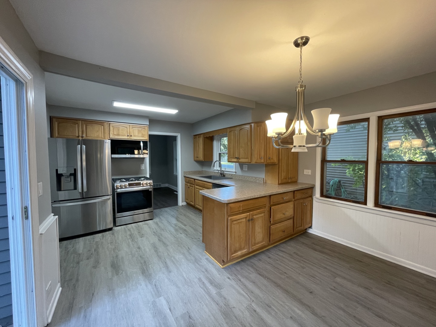 3-s284 Pattermann Road Warrenville, IL 60555 - Photo 7 of 21 a large kitchen with stainless steel appliances granite countertop a refrigerator a oven a island and a wooden floor