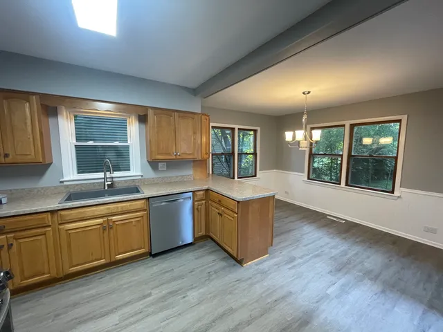 a large kitchen with kitchen island wooden floors and stainless steel appliances