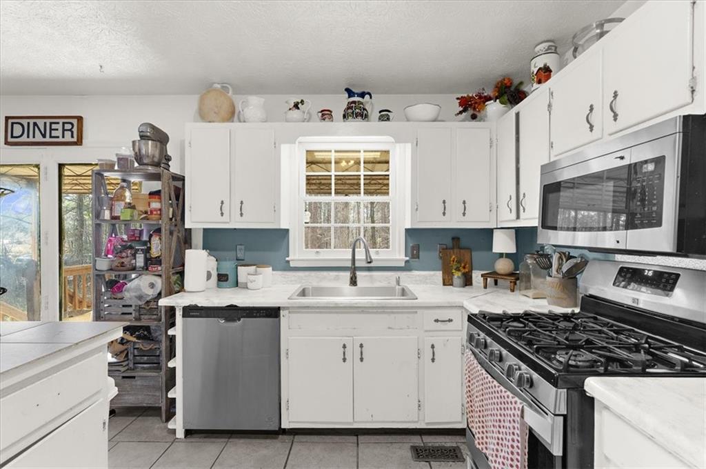 1059 Old Alabama Road Southwest Mableton, GA 30126 - Photo 12 of 33 a kitchen with stainless steel appliances kitchen island granite countertop a sink stove and cabinets
