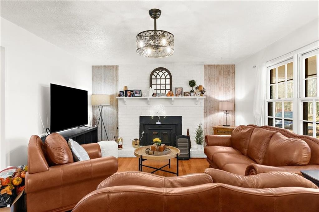 1059 Old Alabama Road Southwest Mableton, GA 30126 - Photo 8 of 33 a living room with furniture a fireplace and a chandelier