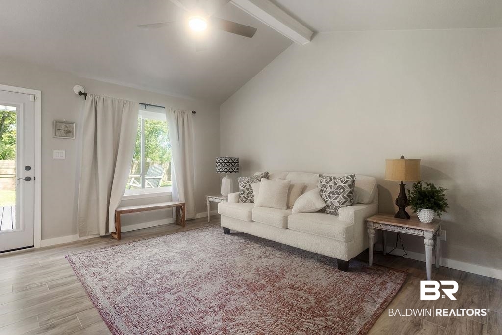 601 East Gate Circle Foley, AL 36535 - Photo 23 of 26 Living room featuring light wood-type flooring, beam ceiling, and a healthy amount of sunlight