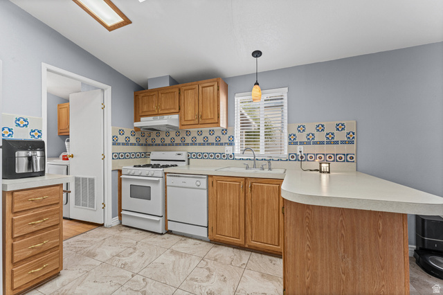 312 Harriger Way Layton, UT 84041 - Photo 20 of 36 Kitchen featuring wood cabinetry, tile flooring, counter seating, white appliances, and a decorative tile backsplash