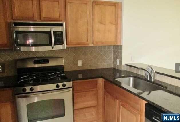 380-382 Anderson Avenue, Unit C1 Cliffside Park, NJ 07010 - Photo 7 of 17 a kitchen with granite countertop a stove sink and microwave