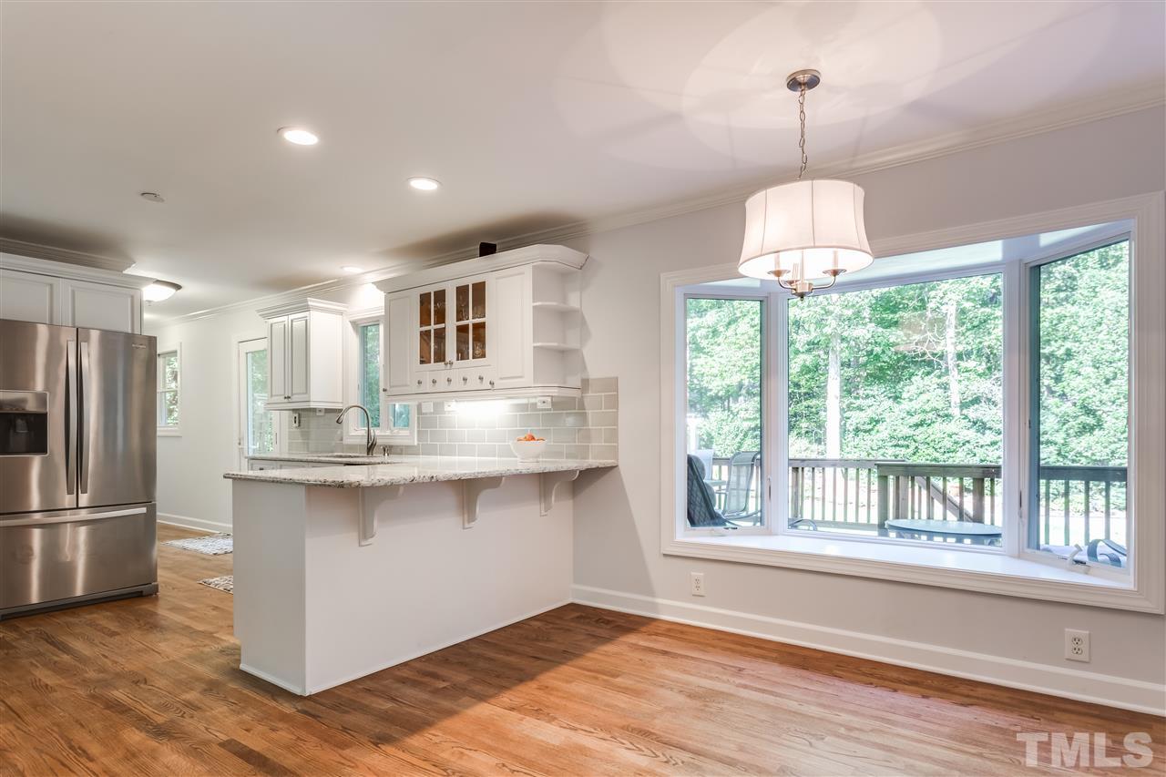 8713 Cliff Top Court Raleigh, NC 27613 - Photo 13 of 25 a view of a kitchen center island wooden floor and stainless steel appliances